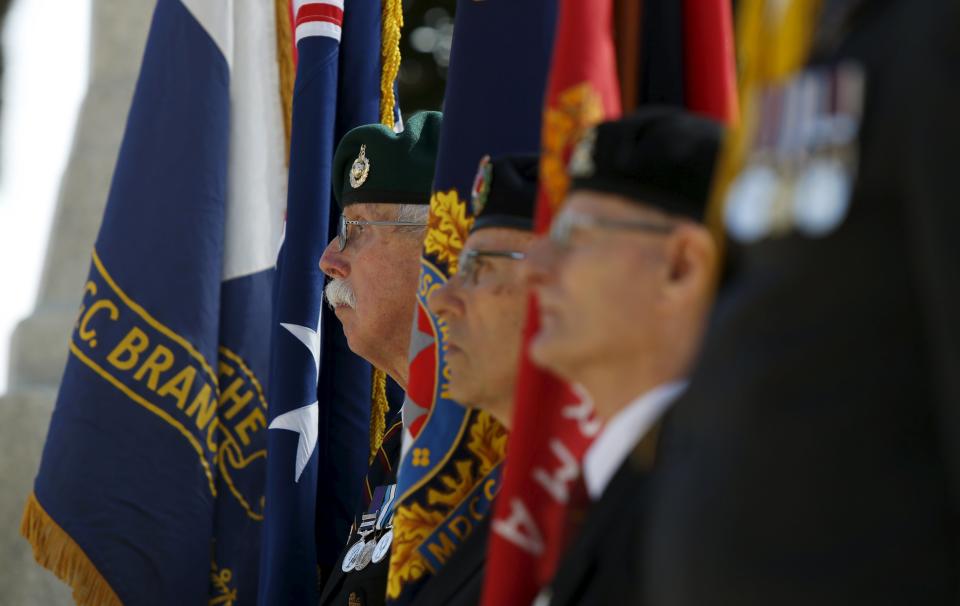 Flag bearers stand at attention during a service to mark the 100th anniversary of ANZAC (Australian and New Zealand Army Corps) landings at Galllipoli, at the Pieta Military Cemetery in Pieta, Malta, April 25, 2015. (REUTERS/Darrin Zammit Lupi)