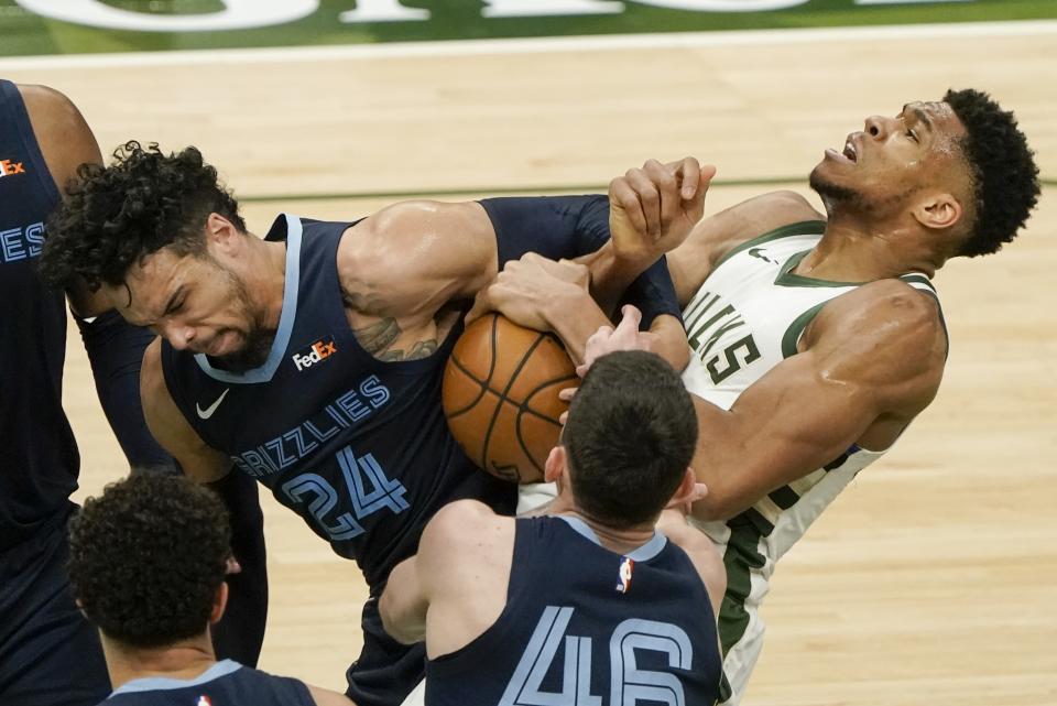 Milwaukee Bucks' Giannis Antetokounmpo and Memphis Grizzlies' Dillon Brooks battle for a loose ball during the first half of an NBA basketball game Saturday, April 17, 2021, in Milwaukee. (AP Photo/Morry Gash)