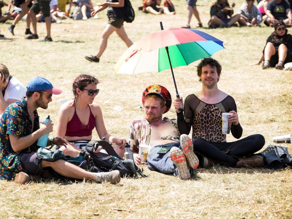 Festival goers take shelter from the sun on the fourth day of Glastonbury Festival (Joel C Ryan/Invision/AP)