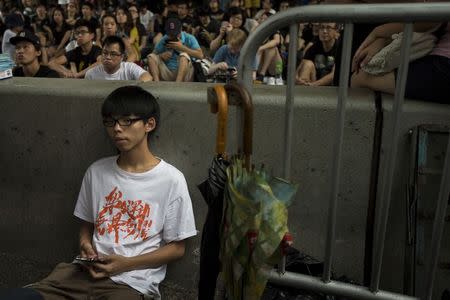Joshua Wong, leader of the student movement, rests after delivering a speech, as protesters block the main street to the financial Central district, outside the government headquarters building in Hong Kong October 4, 2014. REUTERS/Tyrone Siu