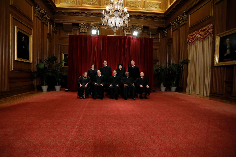 U.S. Chief Justice John Roberts (seated C) leads Justice Ruth Bader Ginsburg (front row, L-R), Justice Anthony Kennedy, Justice Clarence Thomas, Justice Stephen Breyer, Justice Elena Kagan (back row, L-R), Justice Samuel Alito, Justice Sonia Sotomayor, and Justice Neil Gorsuch in taking a new family photo including Gorsuch, their most recent addition, at the Supreme Court building in Washington, D.C., U.S., June 1, 2017.&nbsp;