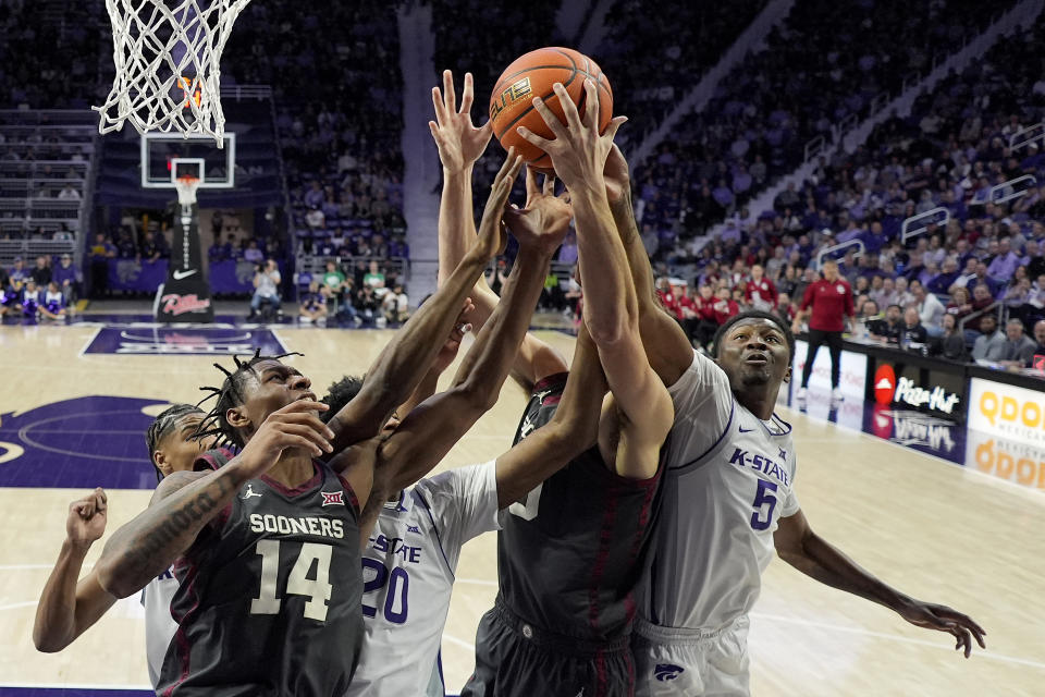 Oklahoma forward Jalon Moore (14), Kansas State forward Jerrell Colbert (20), Oklahoma forward Sam Godwin, second from right, and Kansas State guard Cam Carter (5) battle for a rebound during the first half of an NCAA college basketball game Tuesday, Jan. 30, 2024, in Manhattan, Kan. (AP Photo/Charlie Riedel)