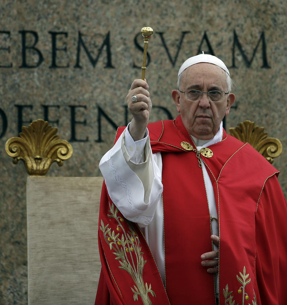 Pope Francis asperges holy water as he celebrates a Palm Sunday mass in St. Peter's Square, at the Vatican, Sunday, April 13, 2014. (AP Photo/Gregorio Borgia)