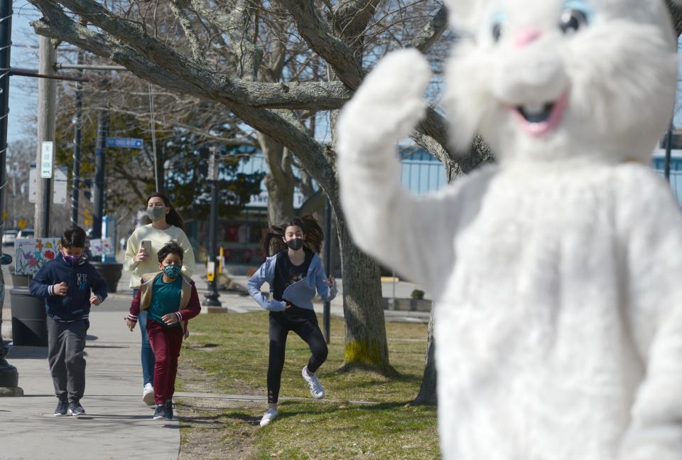 Children run up the sidewalk to check out Jack Sullivan as he portrays the Easter Bunny outside the Kandy Korner along Main Street Hyannis in 2021.