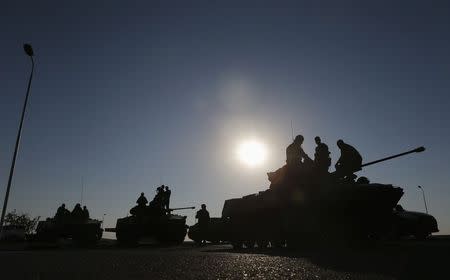 Russian military personnel sit atop armoured vehicles outside Kamensk-Shakhtinsky, Rostov Region, August 15, 2014. REUTERS/Maxim Shemetov