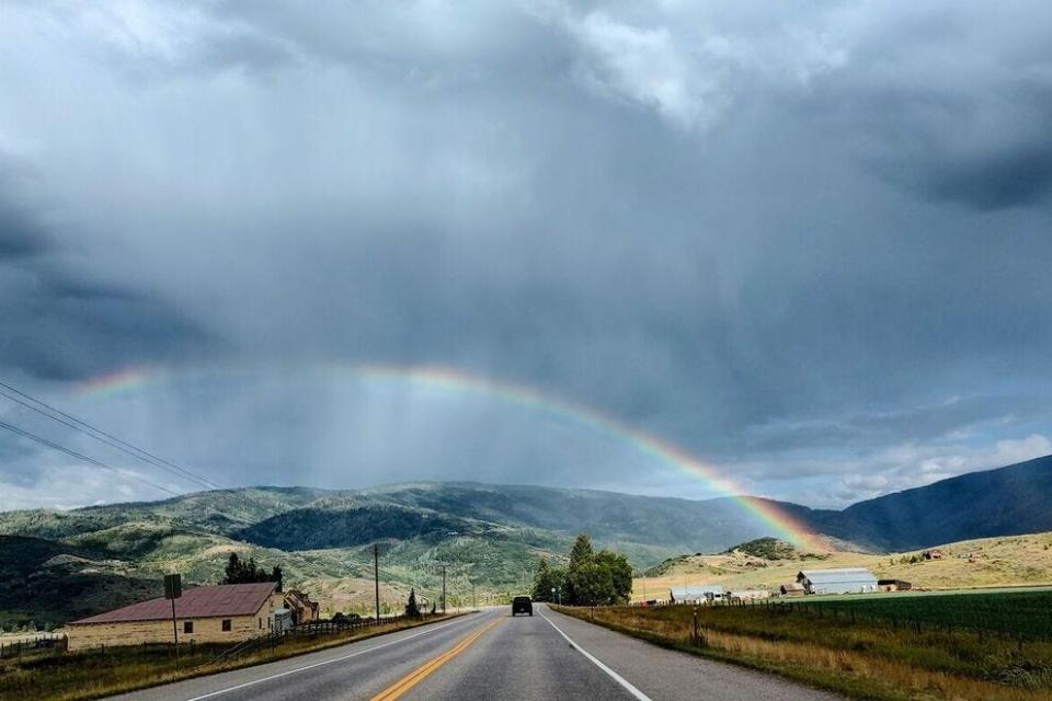 我们驾驶着电动汽车在科罗拉多州菲普斯堡附近的开阔道路上发现了一道彩虹