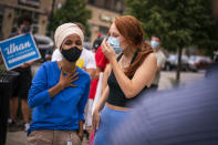 Rep. Ilhan Omar, left, D-Minn., talks with Keaton Sisk outside the Dinkytown Target near the University of Minnesota campus in Minneapolis on Tuesday, Aug. 11, 2020. (Leila Navidi/Star Tribune via AP)