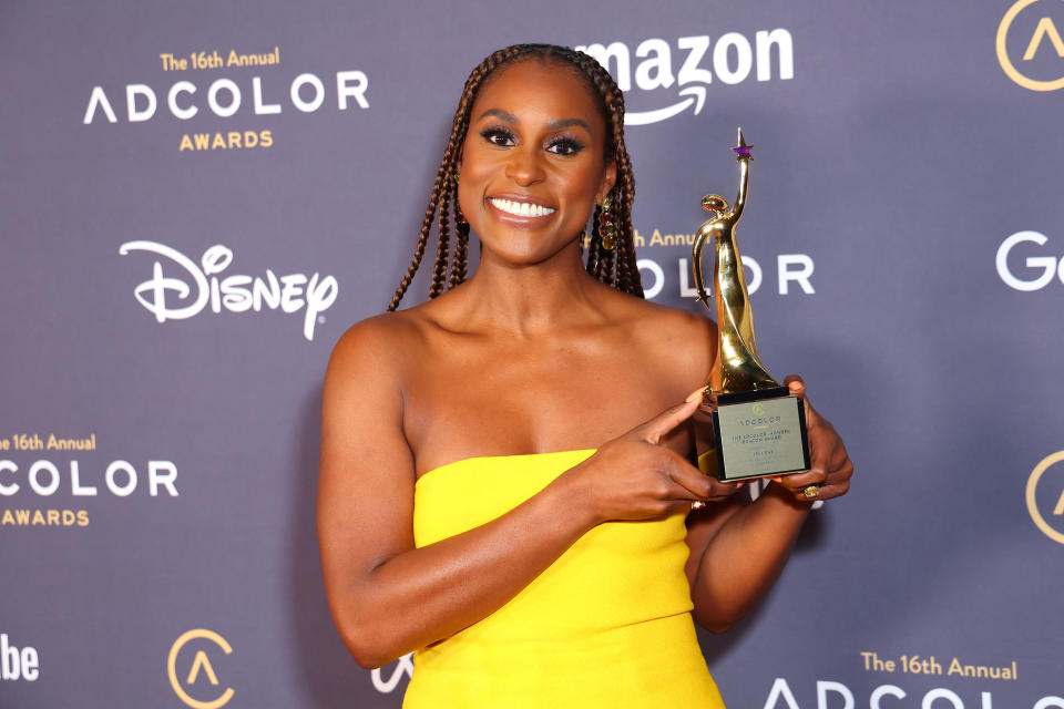 Issa Rae at the adcolor awards wearing a yellow dress. 