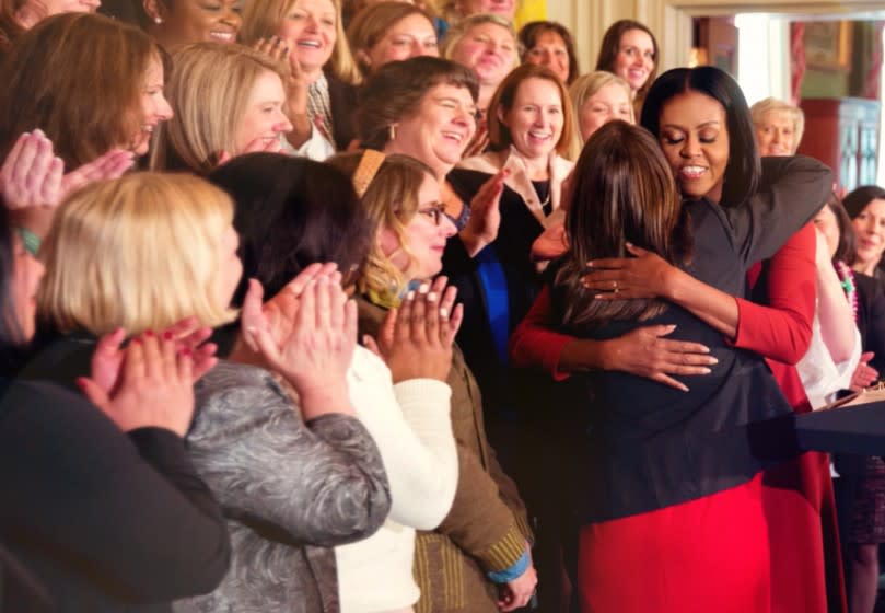 Michelle Obama, as First Lady, embraces an admirer, as seen in the Netflix documentary "Becoming."