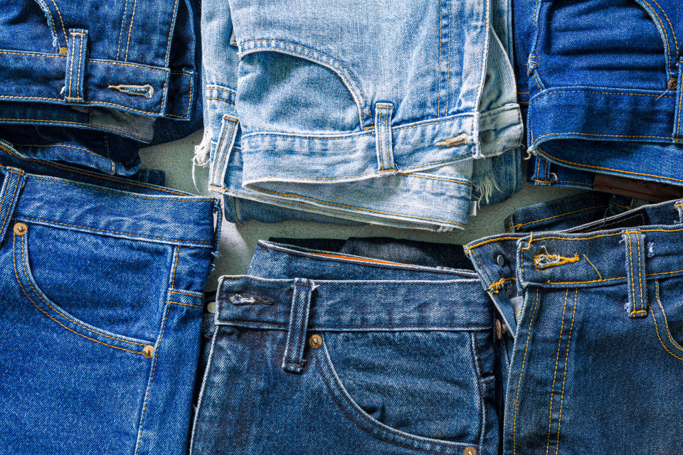 A variety of blue denim jeans laid out flat, showing different styles and washes