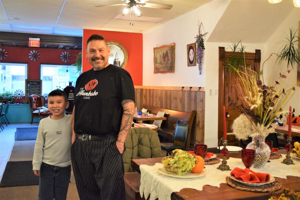 49-year-old Francis Wakeman III and his son, Rufus, stand near a Thanksgiving table spread at his restaurant "The Hunkake Cafe," which serves food inspired by his grandparents' culinary traditions, on Wednesday, November 18th, 2021.