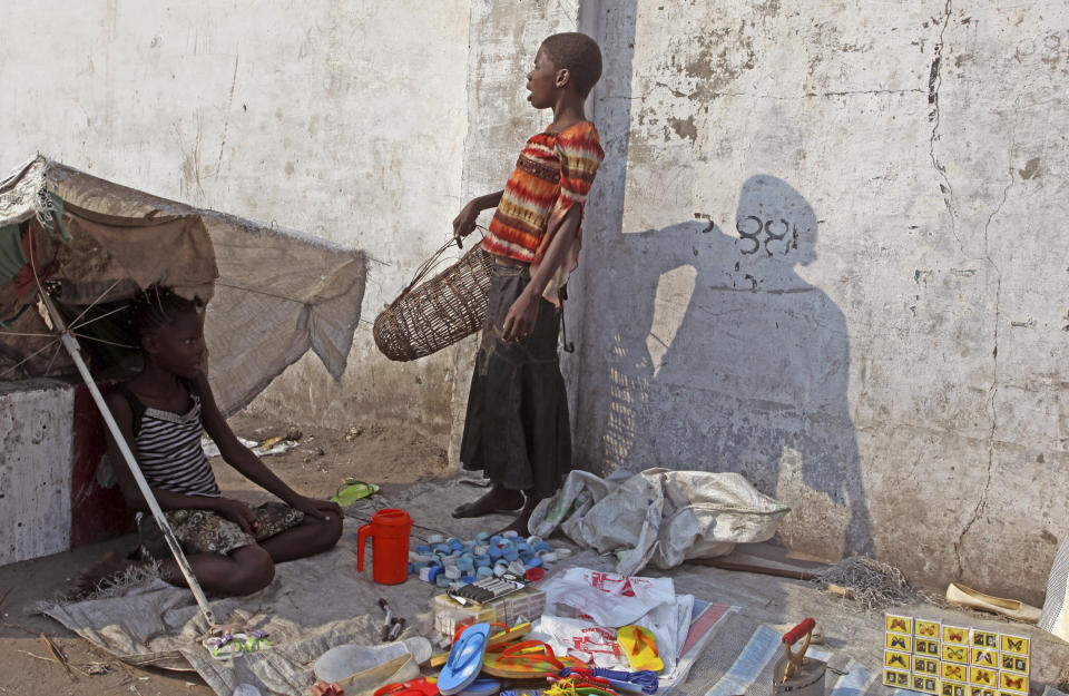 FILE - In this May 28 2014 file photo shot by AP contributing photographer John Bompengo, children stand next to the goods they sell in Kinshasa, Democratic Republic of Congo. Relatives say longtime Associated Press contributor John Bompengo has died of COVID-19 in Congo's capital. Bompengo, who had covered his country's political turmoil over the course of 16 years, died Saturday, June 20, 2020 at a Kinshasa hospital. (AP Photo/John Bompengo, file)