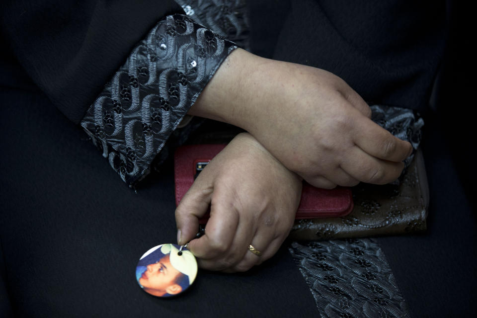 FILE - The mother of Mohammed Abu Khdeir, holds his photo after the reading of the verdict in his killing, at the Jerusalem District Court, Monday, Nov. 30, 2015. An Israeli group that assists Jewish prisoners convicted in some of the country's most notorious hate crimes has halted its fund-raising efforts through a U.S.-based Jewish charity following an investigation by The Associated Press and the Israeli investigative platform Shomrim. (AP Photo/Oded Balilty, file)