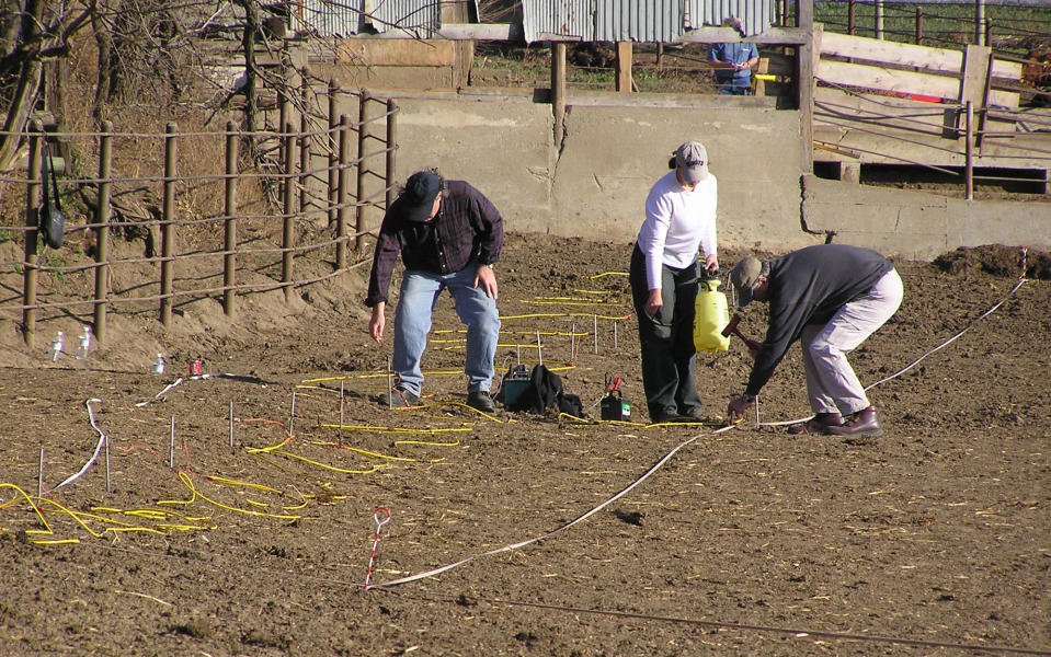 FILE - In this Nov. 16, 2004 file photo investigators stake out a feedlot on a farm near Nora, S.D., searching for evidence in the disappearance of Pamella Jackson and Cheryl Miller. The search yielded nothing and the girls disappearance baffled investigators for more than four decades. On April 15, 2014 authorities said the remains of the two 17-year-old South Dakota girls had been found in a car, upside-down in a creek near the party they were driving to celebrate the end of the school year with classmates in 1971. (AP Photo/Carson Walker, File)