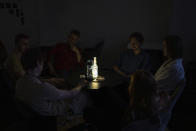 Friends sit in a coffee shop during a blackout in Kyiv, Ukraine, Friday, June 7, 2024. (AP Photo/Alex Babenko)