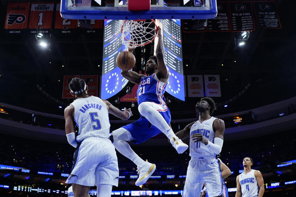 Philadelphia 76ers' Joel Embiid (21) dunks past Orlando Magic's Paolo Banchero (5) and Mo Bamba (11) during the first half of an NBA basketball game, Monday, Jan. 30, 2023, in Philadelphia. (AP Photo/Matt Slocum)