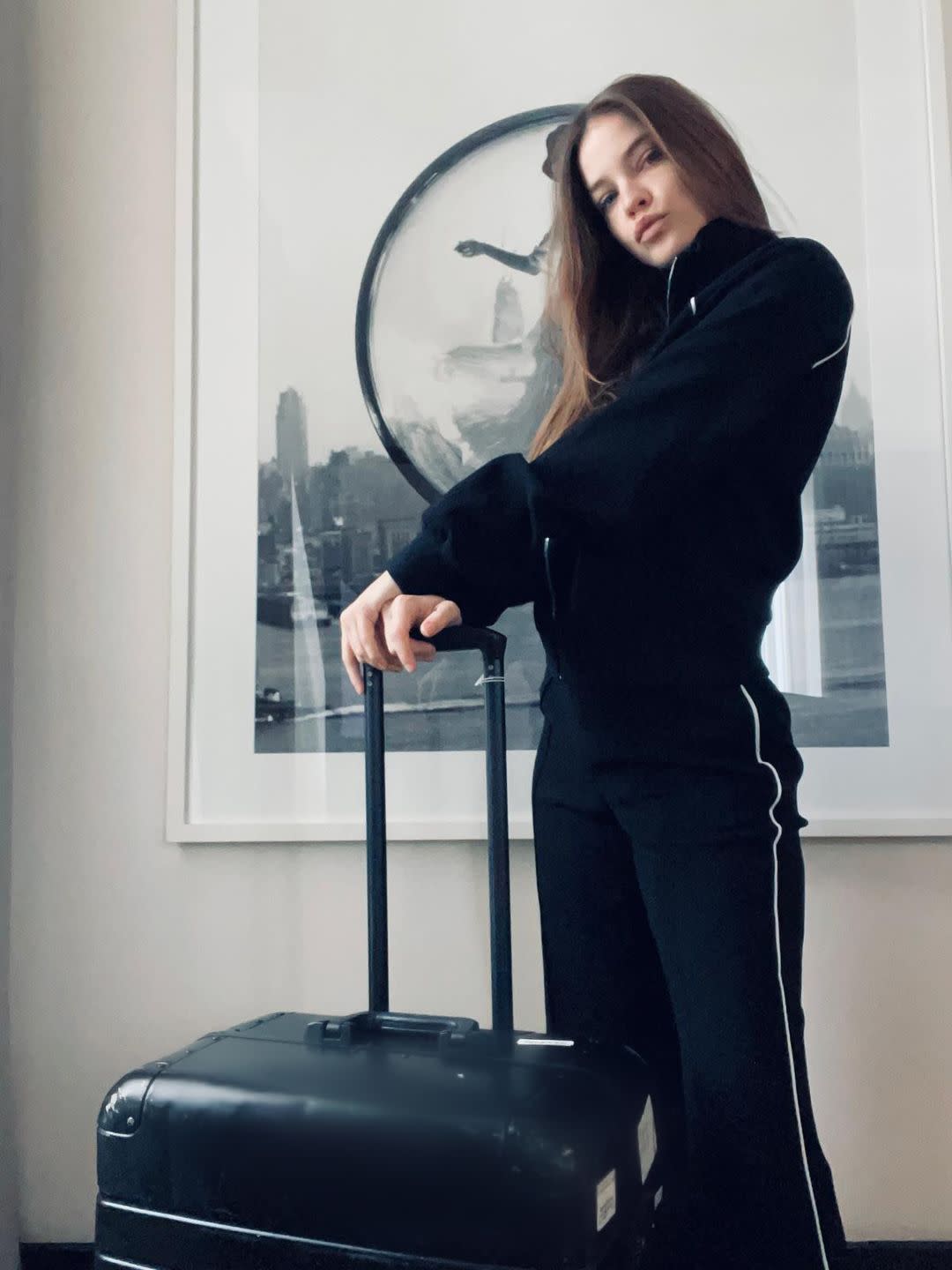 a woman standing next to a suitcase