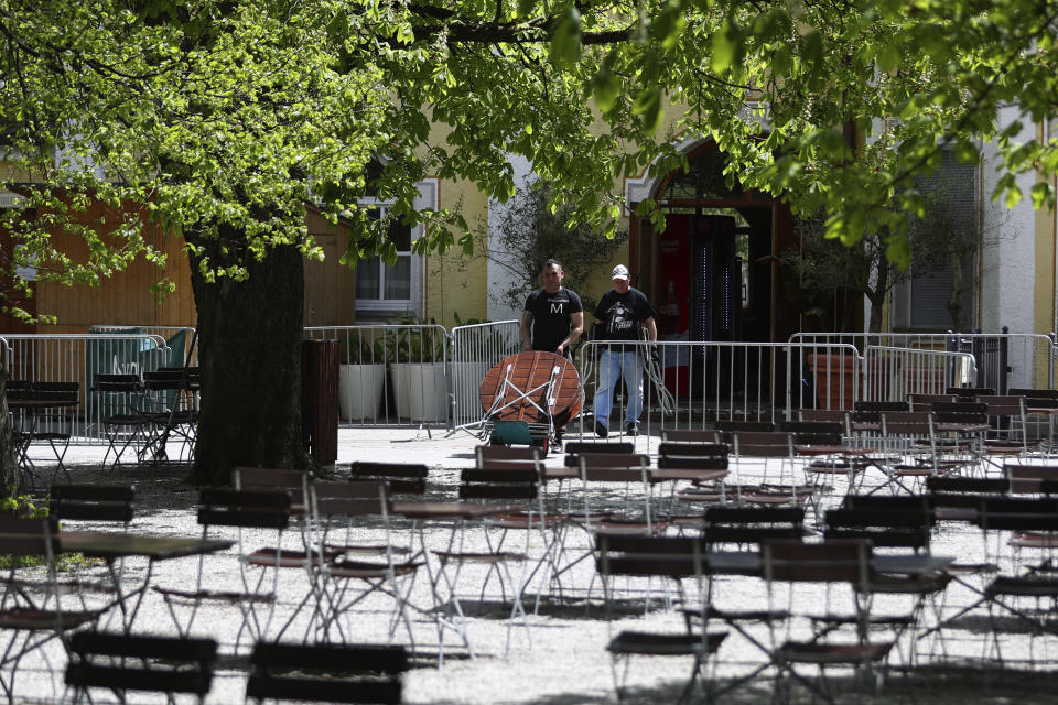Employees of the 'Taxisgarten' beer garden prepare benches and tables for the re-opening in Munich, Germany, Monday, May 10, 2021. (AP Photo/Matthias Schrader)