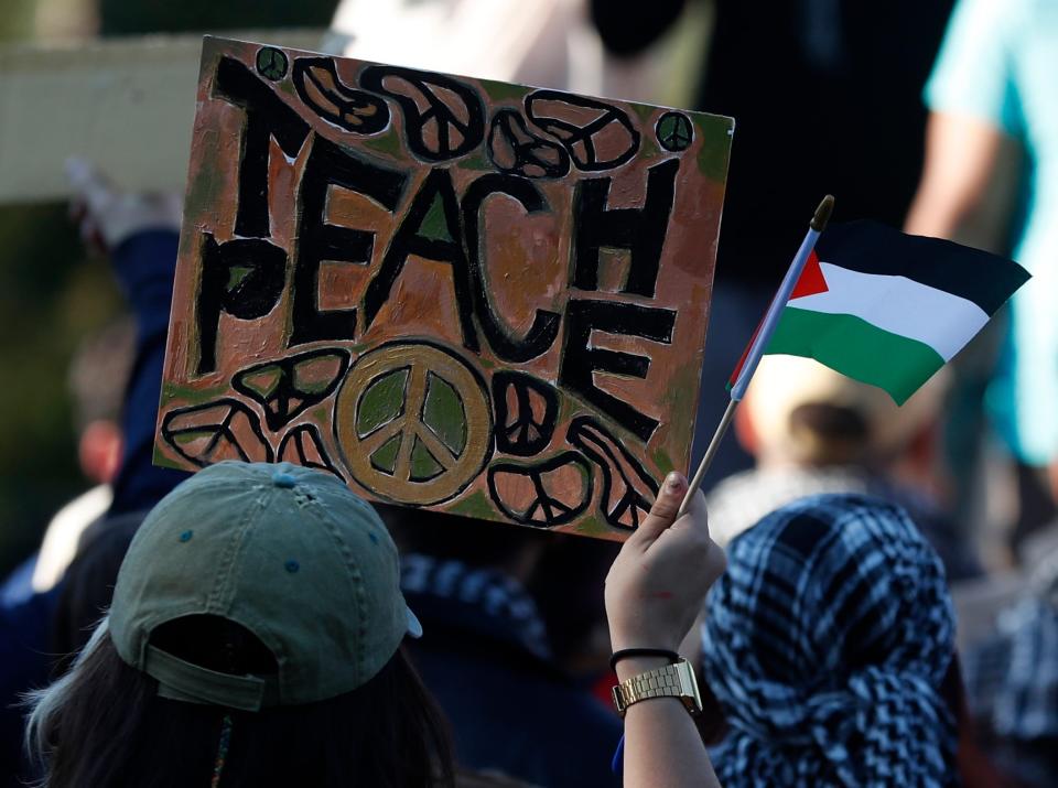 Protesters hold up signs in response to the Palestine and Israel conflict, Thursday, Oct. 12, 2023, at Purdue University in West Lafayette, Ind.