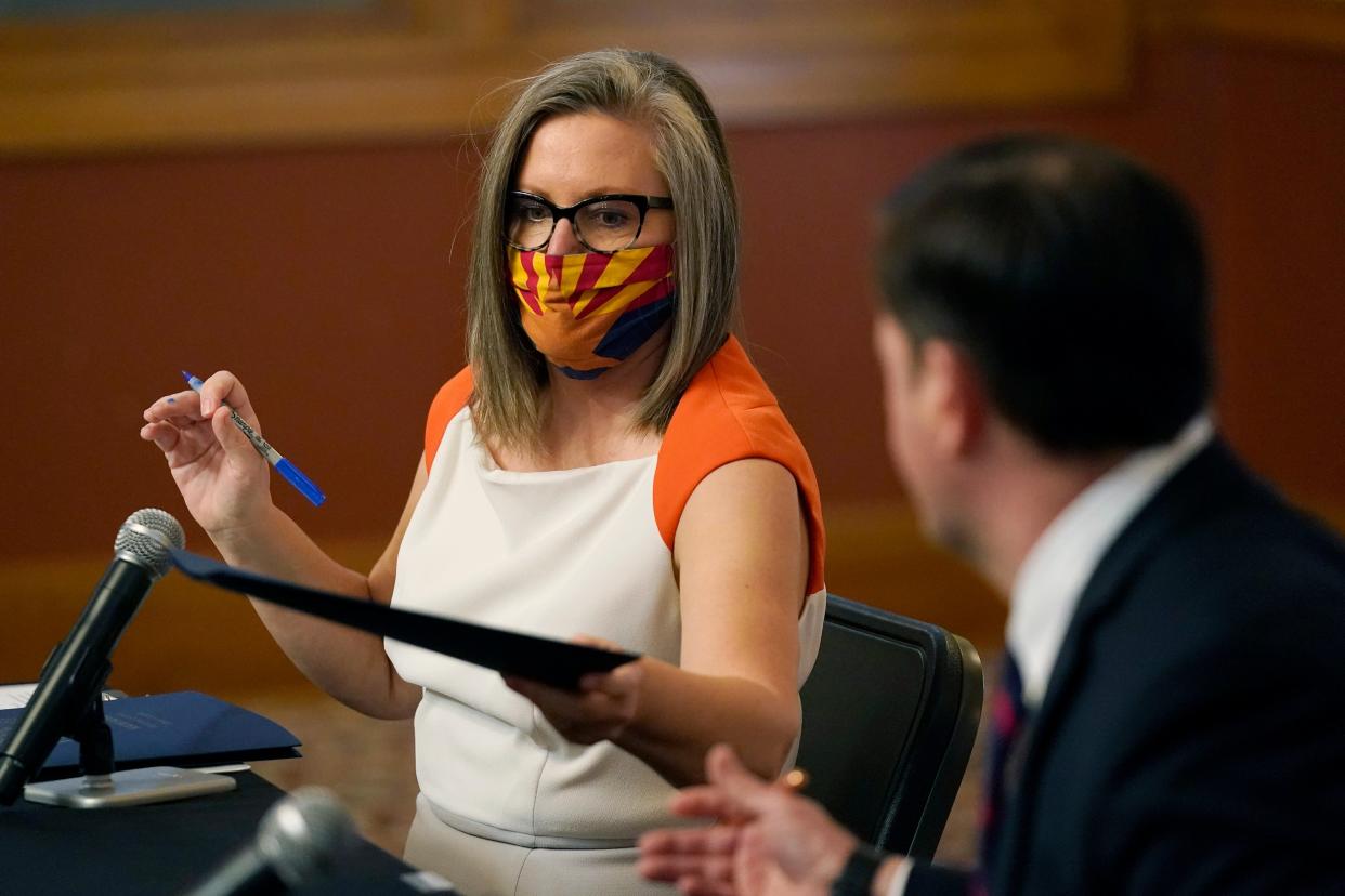 <p>Arizona Secretary of State Katie Hobbs hands over voting certification documents to Arizona Governor Doug Ducey on 30 November in Phoenix.</p> (AP)