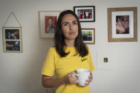 Juliana Macedo do Nascimento, 36, a Deferred Action for Childhood Arrivals program recipient who moved to the U.S. from Brazil when she was 14, poses for a portrait by images of her brother who has returned to Brazil, and family in the United States, Friday, Sept. 2, 2022, in her apartment in Washington. Immigrants who signed up for an Obama-era program shielding them from deportation, long a symbol of youth, are increasingly easing into middle age. (AP Photo/Jacquelyn Martin)