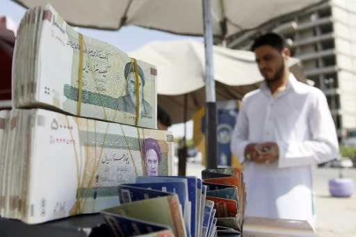 A vendor in Iraq's shrine city of Najaf sells Iranian rials, which have lost half their value against the dollar since April, slashing Iranian pilgrims' buying power