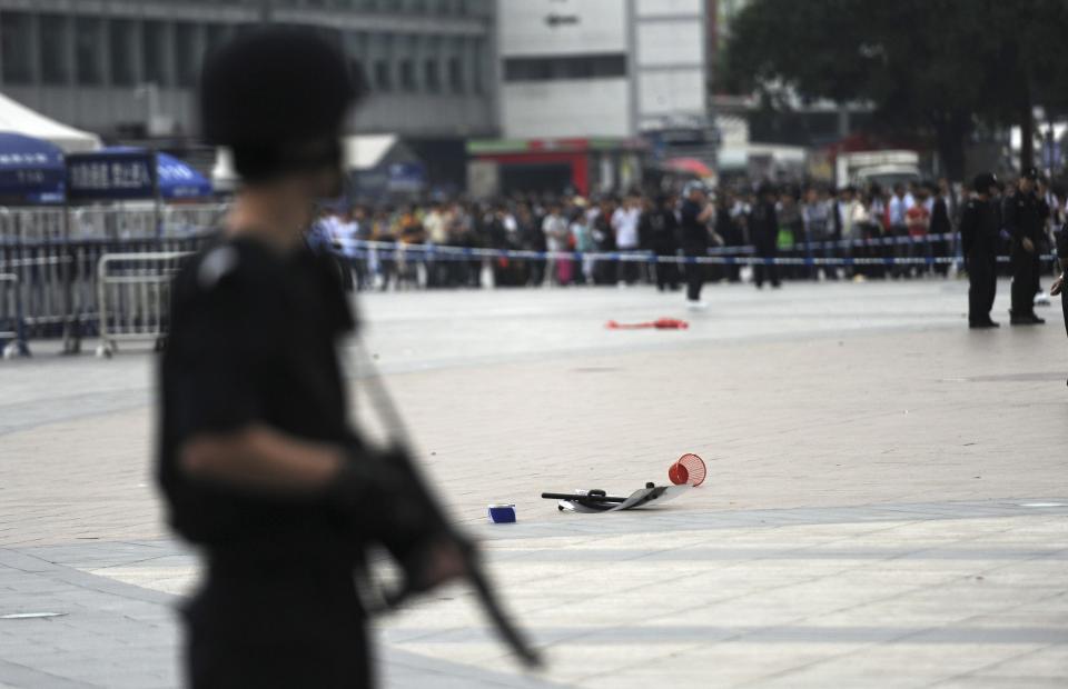 REFILE - ADDITIONAL CAPTION INFORMATION An armed policeman (front) stands guard near a police shield (C) that was left on the ground after a scuffle between a police officer and an attacker, at a railway station in Guangzhou, Guangdong province May 6, 2014. Six people were wounded in the knife attack at a railway station in the southern Chinese city of Guangzhou on Tuesday, police said, the latest in a series of such assaults that have raised jitters around the country. REUTERS/Stringer (CHINA - Tags: CIVIL UNREST CRIME LAW TRANSPORT TPX IMAGES OF THE DAY) CHINA OUT. NO COMMERCIAL OR EDITORIAL SALES IN CHINA