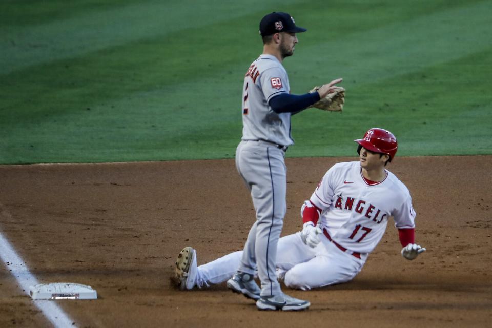 Angels pitcher Shohei Ohtani slides safely into third base on a second-inning triple.