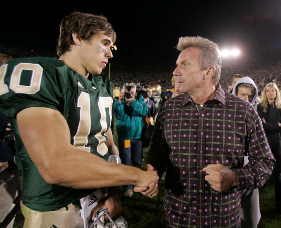 Former Notre Dame quarterback Joe Montana talks with Brady Quinn (10) after an Irish loss to USC in the “Bush Push” game at Notre Dame Stadium in 2005.