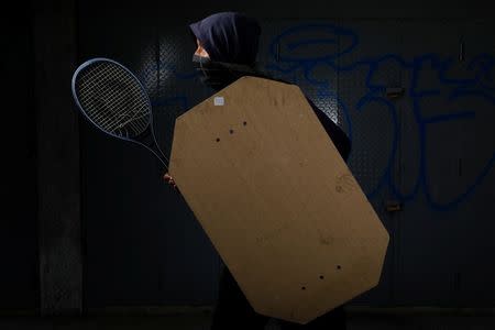 A demonstrator holding a rudimentary shield and a tennis racket poses for a picture before a rally against Venezuelan President Nicolas Maduro's government in Caracas, Venezuela, May 27, 2017. He said: "I protest for the future of my country." REUTERS/Carlos Garcia Rawlins