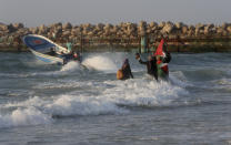 Palestinian women hold national flag during a protest on the beach at the border with Israel near Beit Lahiya, northern Gaza Strip, Monday, Sept. 17, 2018. (AP Photo/Adel Hana)