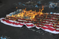 A mock U.S. flag is set on fire by demonstrators during a rally in front of the former U.S. Embassy commemorating the anniversary of its 1979 seizure in Tehran, Iran, Thursday, Nov. 4, 2021. The embassy takeover triggered a 444-day hostage crisis and break in diplomatic relations that continues to this day. (AP Photo/Vahid Salemi)