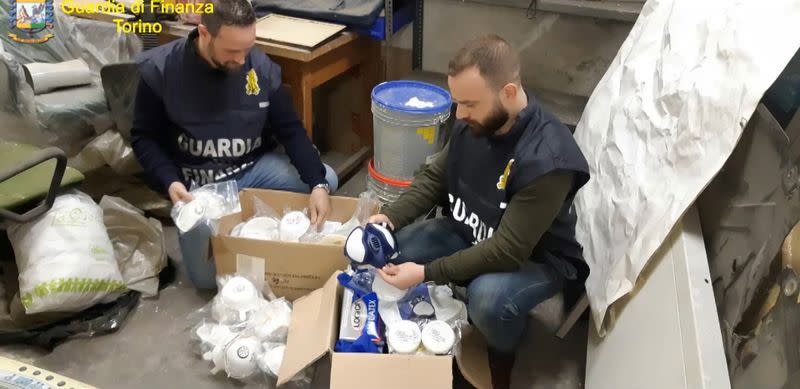 Italian finance police check protective masks that were seized because they were being sold for exorbitant prices by Italian companies, in Turin
