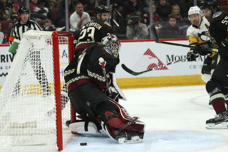 Pittsburgh Penguins right wing Patric Hornqvist, second from right, scores a goal against Arizona Coyotes goaltender Adin Hill, left, as Coyotes defensemen Oliver Ekman-Larsson (23) and Jason Demers (55) look on during the second period of an NHL hockey game Sunday, Jan. 12, 2020, in Glendale, Ariz. (AP Photo/Ross D. Franklin)