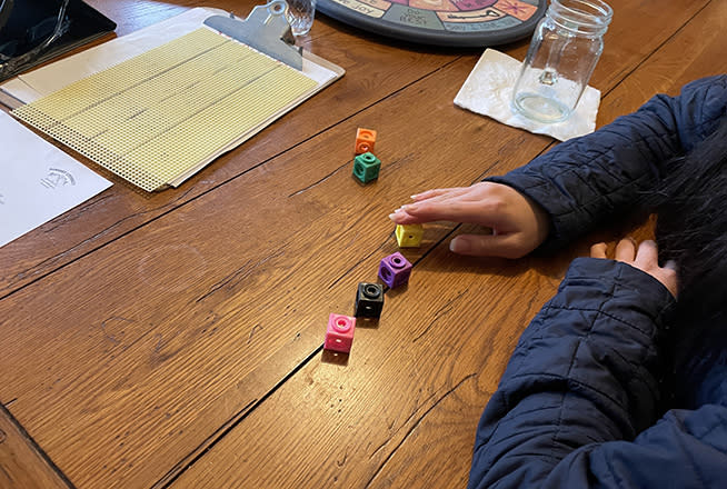 Kim Paige’s daughter uses manipulatives like brightly colored blocks to reinforce spelling and reading lessons. (Asher Lehrer-Small)