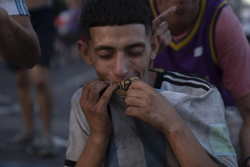 A soccer fan kisses the Argentine soccer team jersey his wearing after celebrating through the night his team's victory over France in the final match of the World Cup, in downtown Buenos Aires, Argentina, Monday, Dec. 19, 2022. (AP Photo/Matilde Campodonico)