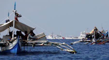 China Coast Guard vessels patrol past Philippine fishing boats at the disputed Scarborough Shoal, April 5, 2017. Picture taken April 5, 2017. REUTERS/Erik De Castro