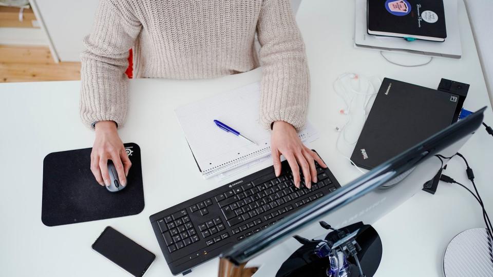 Eine Frau arbeitet in ihrer Wohnung vor einem Computer an einem Stehtisch. (Symbolbild)