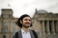 Hakan Demir, grandson of Turkish immigrants, smiled as he poses for a photo during an interview with the Associated Press in front of the German parliament Bundestag building, the Reichstag Building, in Berlin, Tuesday, Sept. 28, 2021. Sunday's national election making Germany's lower house of parliament, or Bundestag, more diverse and inclusive than ever before. For the first time there are also two transgender women, at least three people of African descent and, after years of stagnation, the number of female lawmakers has gone up again as well. (AP Photo/Markus Schreiber)