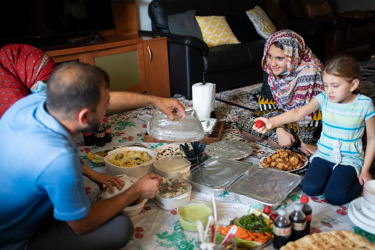 The Mashwani family sits down for dinner on Aug. 28. They came to Columbus after the U.S. withdrew from Afghanistan in 2021.