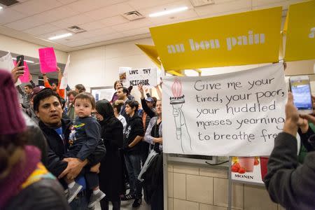 A protest sign hangs from a vendor both as people gather to protest against the travel ban imposed by U.S. President Donald Trump's executive order, at Dallas/Fort Worth International Airport in Dallas, Texas, U.S. January 28, 2017. REUTERS/Laura Buckman