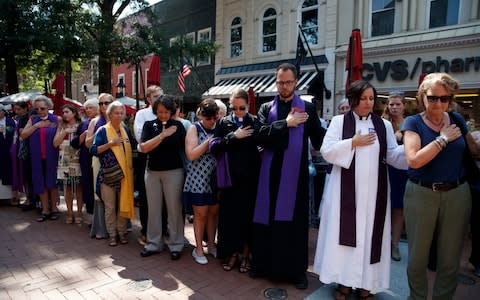 Mourners and clergy pray outside the memorial service  - Credit: AP