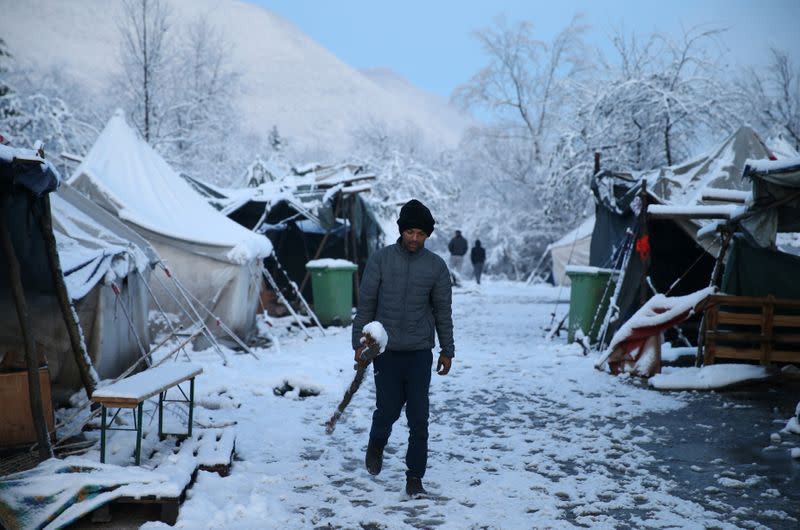 A migrant walks in a snow covered makeshift forest camp near Croatian border in Bihac