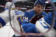 Colorado Avalanche center Nathan MacKinnon, right, checks St. Louis Blues left wing Jaden Schwartz in the corner in the first period of Game 1 of an NHL hockey Stanley Cup first-round playoff series Monday, May 17, 2021, in Denver. (AP Photo/David Zalubowski)