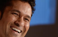 Indian cricketer Sachin Tendulkar smiles during the launch of a limited edition 10 gram gold coin with an embossed image of himself on Akshaya Tritiya in Mumbai on May 13, 2013. A total of 100, 000 limited edition 10 gram Tendulkar Gold coins priced at INR 34,000 (USD 618) will be available for both online purchase and at retail stores of leading jewellers across the country. Akshaya Tritiya is considered to be an auspicious day in the Hindu calendar to buy valuables and people generally flock to buy gold on this day in the belief that it will increase their wealth. AFP PHOTO/ Indranil MUKHERJEE