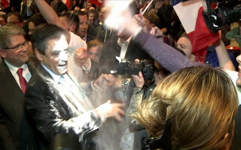 Francois Fillon reacting as a man throw flour at him - Credit: JULIEN SENGEL/AFP