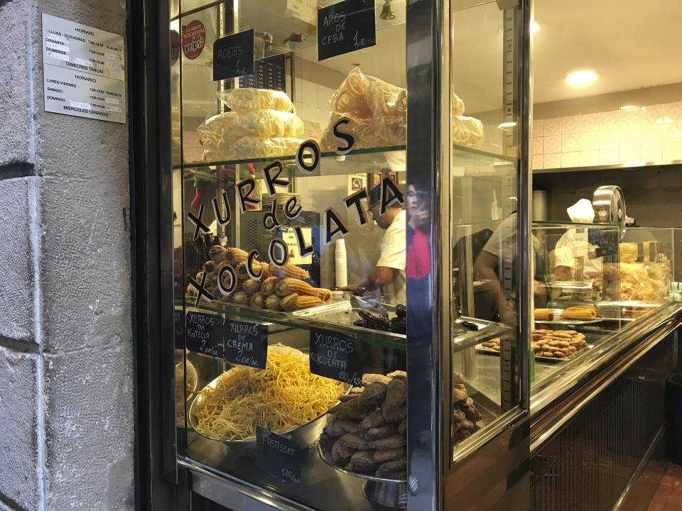 This Oct. 7, 2019 photo shows churros and other fried treats on display at Xurreria, a small shop famous for its churros and chocolate, in the Gothic Quarter of Barcelona, Spain. If you’re taking a solo trip for the first time, a European city like Barcelona is a good place to start. The city is dynamic, the streets and cafes are always packed, it’s safe to walk around at night and people mostly speak English. (Courtney Bonnell via AP)