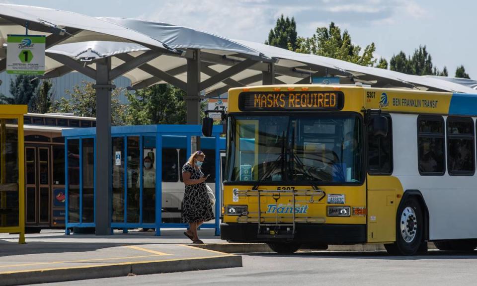 Ben Franklin Transit bus flashes a “Mask Required” message across the front reader board as passengers board at the Three Rivers Transit Center bus station in Kennewick.