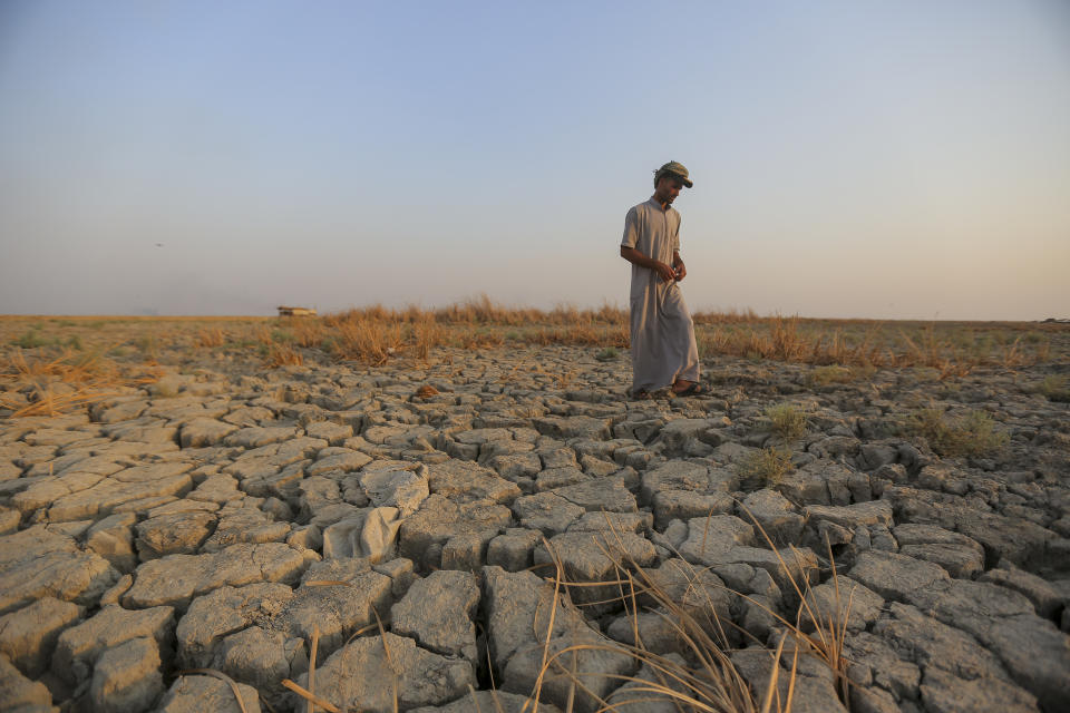 FIEL - A fisherman walks across a dry patch of land in the marshes in Dhi Qar province, Iraq, Sept. 2, 2022. The three-year drought that has left millions of people in Syria, Iraq and Iran with little water wouldn’t have happened without human-caused climate change, according to a new study on Wednesday, Nov. 8, 2023. (AP Photo/Anmar Khalil, File)