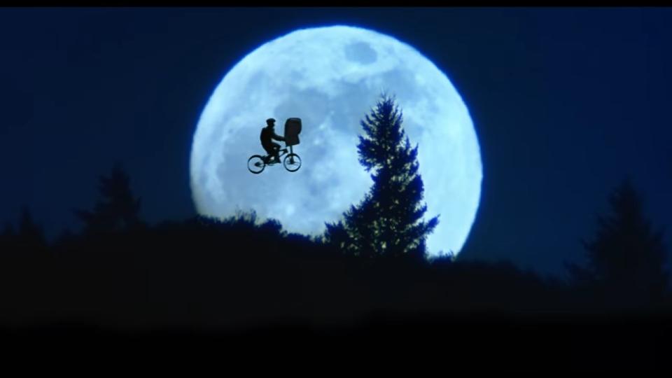 Elliot flying on his bike with E.T. with the moon in the sky in "E.T. The Extra-Terrestrial"